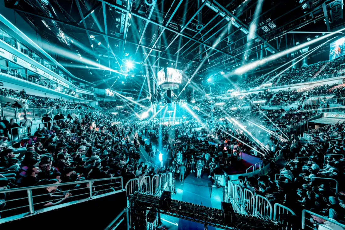 Arena show with beams of stage light over the crowd